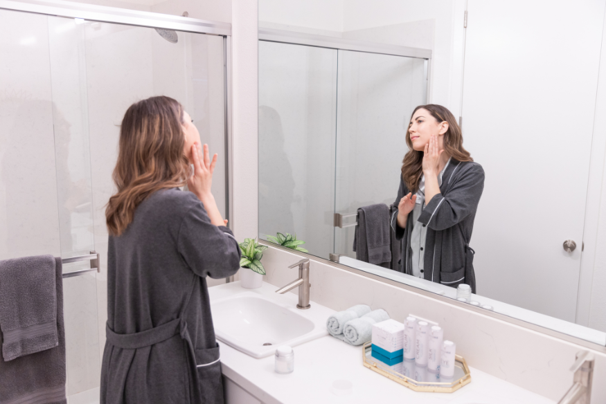 Woman examines skin for signs of aging