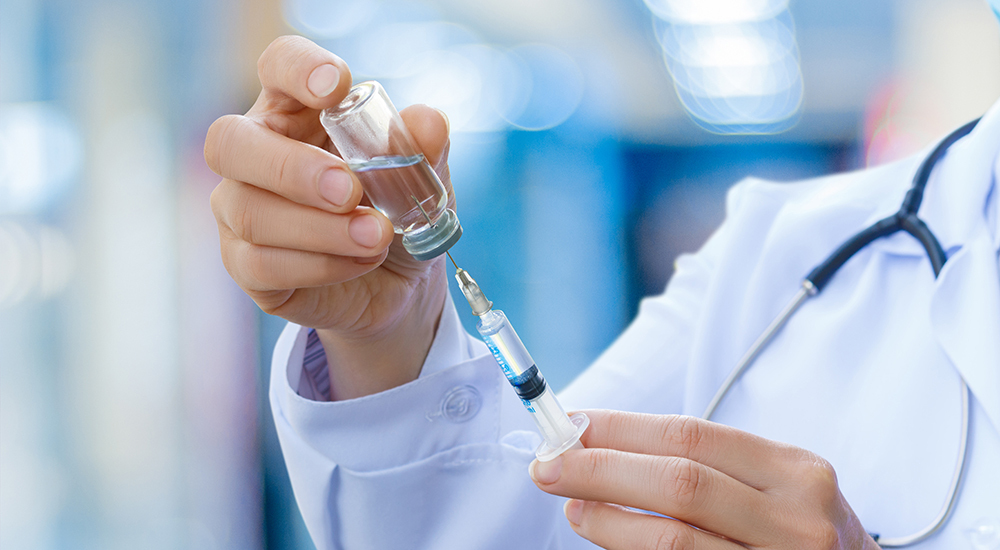 medical professional readies syringe for injection