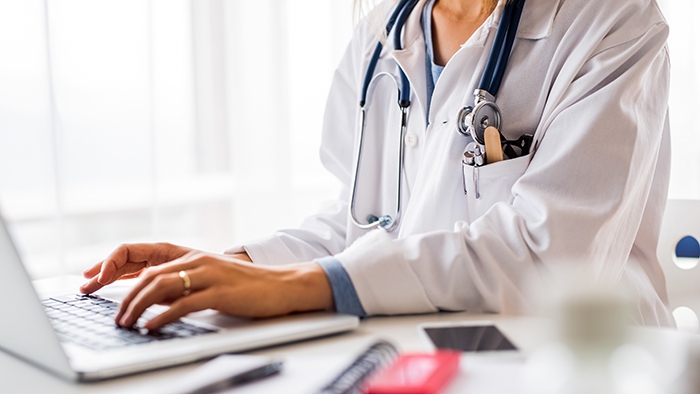 Woman in lab coat at computer