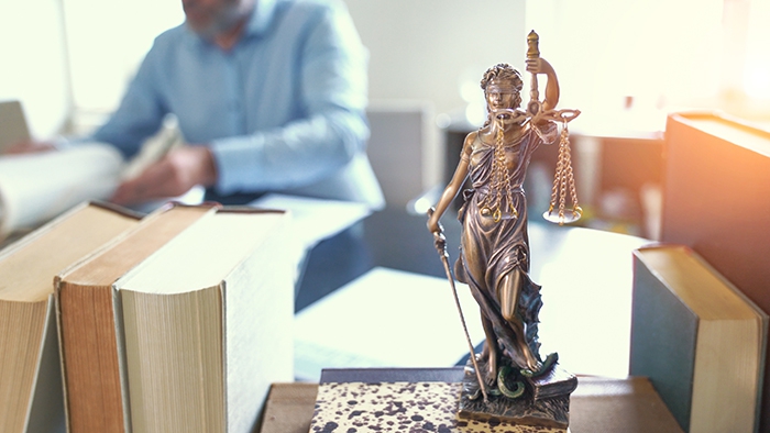 Lawyer's desk with books and lady justice