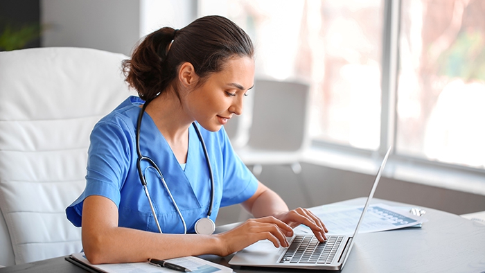 Nurse practitioner types on laptop
