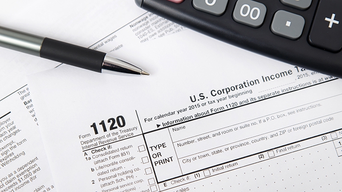 Business tax form 1120, with pen and calculator